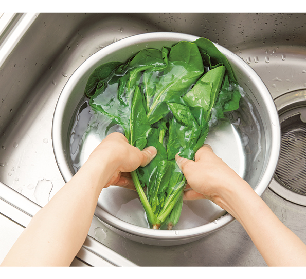 青菜を水で洗っている写真